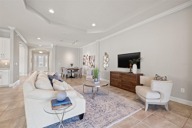 living room featuring ornamental molding, a tray ceiling, light tile patterned floors, and baseboards