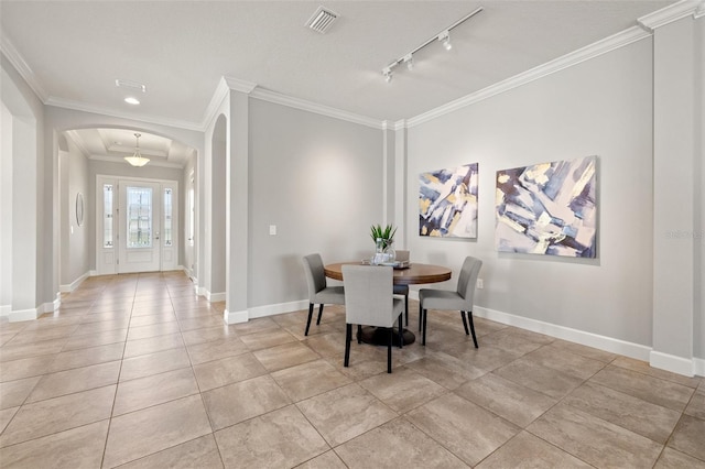 dining area with baseboards, visible vents, arched walkways, and crown molding