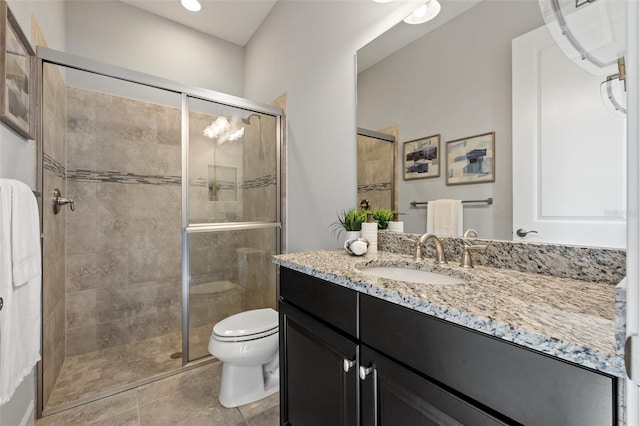 bathroom featuring toilet, a shower stall, vanity, and tile patterned floors