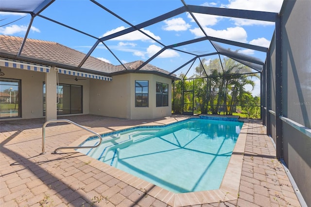 outdoor pool with glass enclosure and a patio area