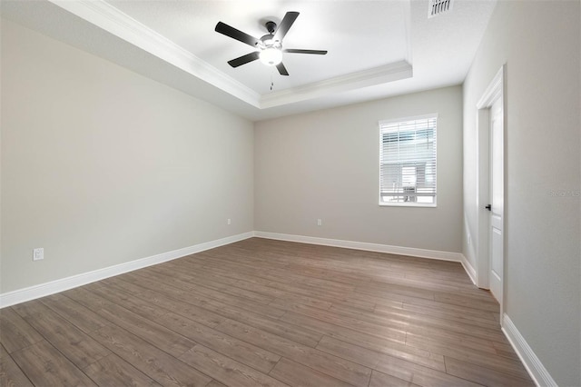 spare room featuring hardwood / wood-style floors, a tray ceiling, and ceiling fan