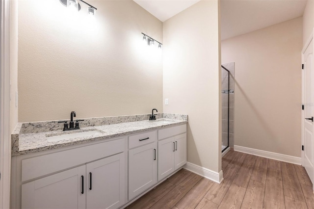 bathroom featuring vanity, hardwood / wood-style floors, and a shower with shower door