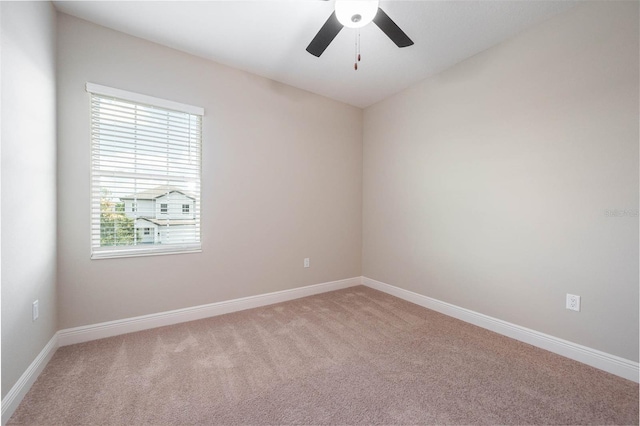 carpeted spare room featuring ceiling fan