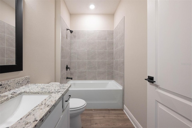 full bathroom with toilet, tiled shower / bath, hardwood / wood-style floors, and vanity