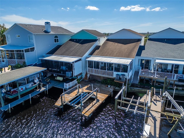 rear view of house with a water view and a sunroom