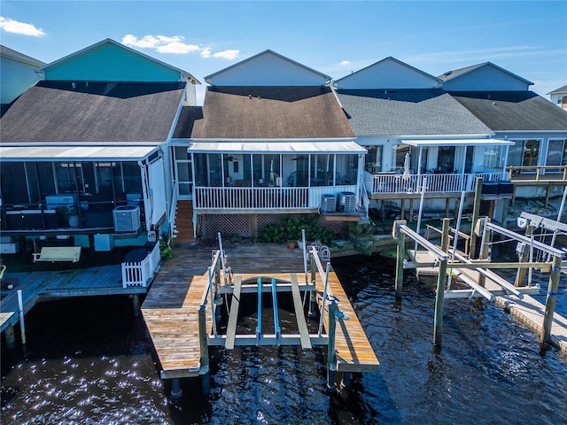 back of house featuring a water view and a sunroom