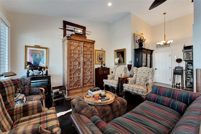 living room with a chandelier, vaulted ceiling, and dark hardwood / wood-style flooring