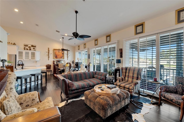 living room featuring dark wood-type flooring, vaulted ceiling, ceiling fan, and plenty of natural light