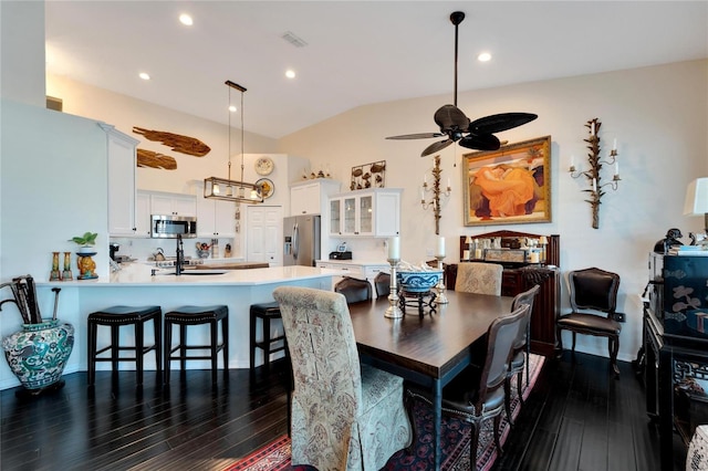 dining area with dark wood-type flooring, vaulted ceiling, and ceiling fan