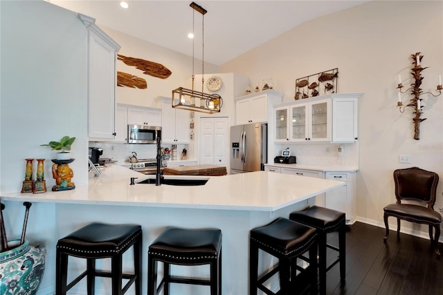 kitchen with lofted ceiling, dark wood-type flooring, white cabinetry, and stainless steel appliances