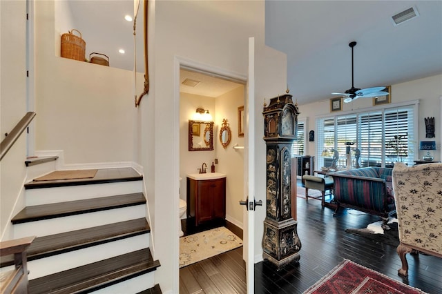 stairway with wood-type flooring and ceiling fan