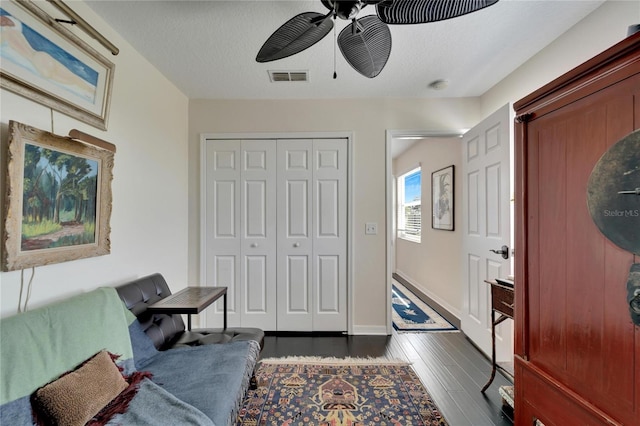 foyer entrance featuring dark wood-type flooring, a textured ceiling, and ceiling fan