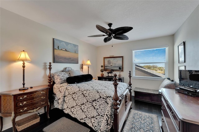 bedroom with ceiling fan, a textured ceiling, and dark hardwood / wood-style flooring