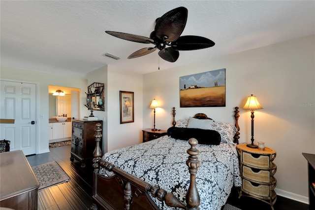 bedroom featuring connected bathroom, dark wood-type flooring, a textured ceiling, and ceiling fan