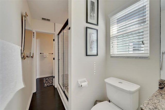 bathroom with toilet, walk in shower, and wood-type flooring