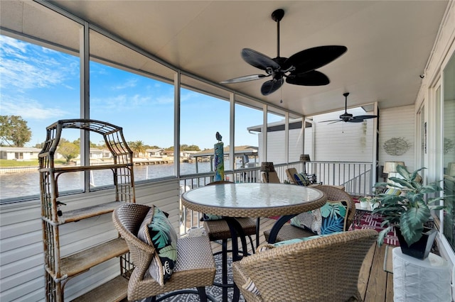 sunroom / solarium featuring a wealth of natural light, a water view, and ceiling fan