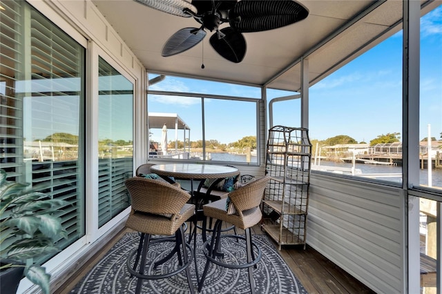 sunroom featuring ceiling fan, a water view, and a wealth of natural light