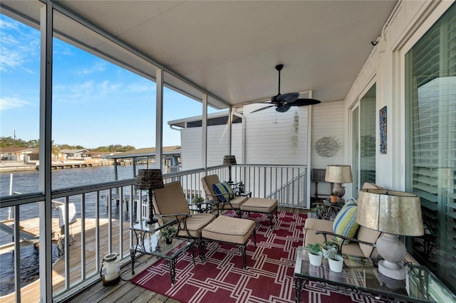 sunroom featuring a water view and ceiling fan