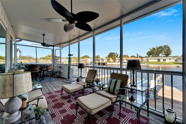 sunroom / solarium with a water view and ceiling fan