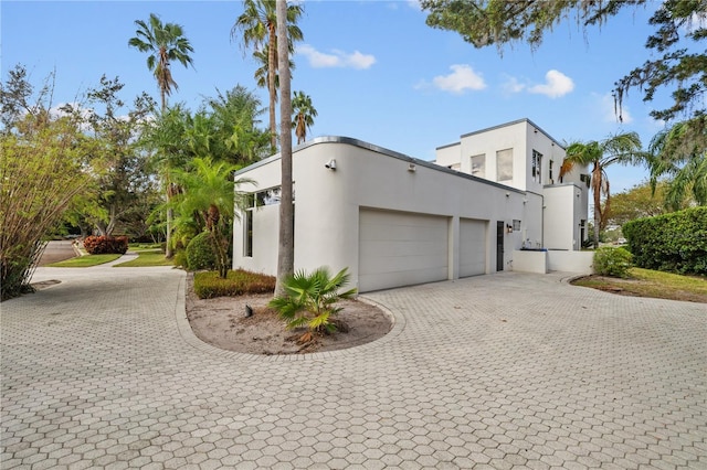 2905 Safe Harbor Dr, Tampa, FL 33618 - view of home's exterior with decorative driveway, an attached garage, and stucco siding