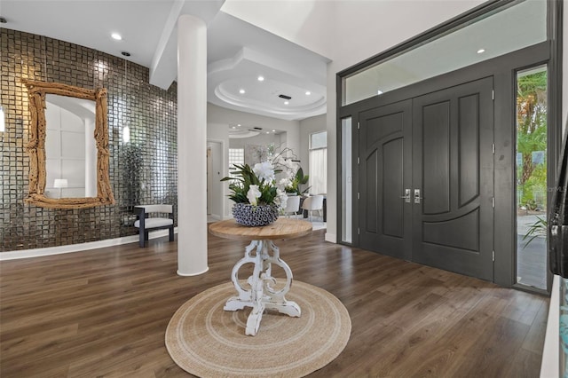 foyer entrance with dark hardwood / wood-style floors and brick wall