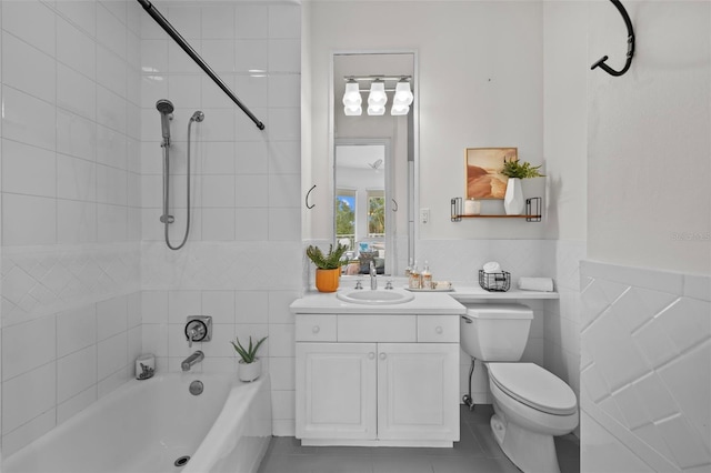 full bathroom with tiled shower / bath combo, vanity, tile walls, and toilet