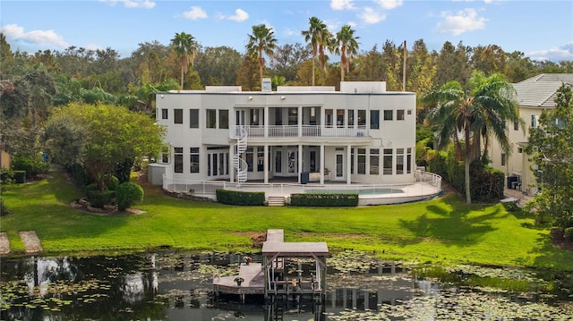 back of property featuring a lawn, a balcony, a patio, and a water view