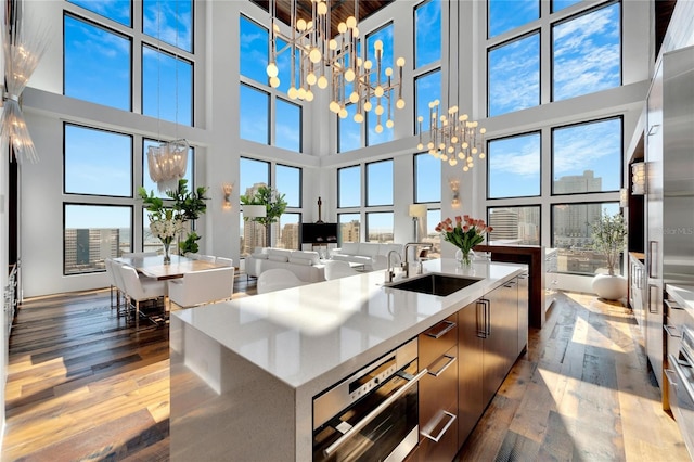 kitchen featuring a high ceiling, hanging light fixtures, a large island, and sink