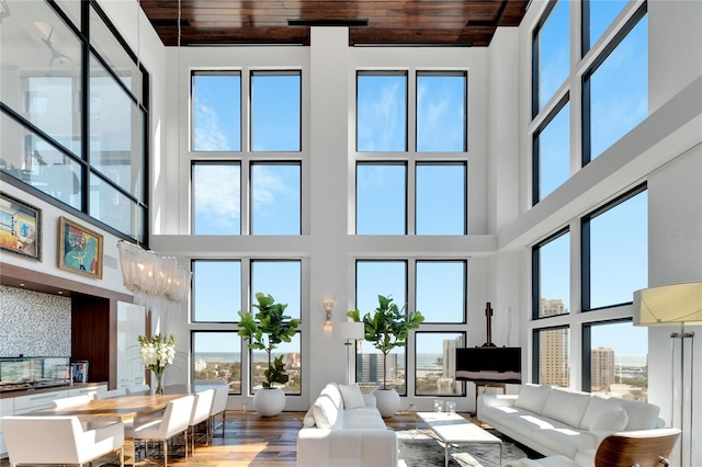 living room with hardwood / wood-style flooring, wood ceiling, and a towering ceiling