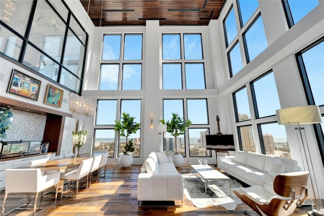 living room with hardwood / wood-style floors, wooden ceiling, and a high ceiling