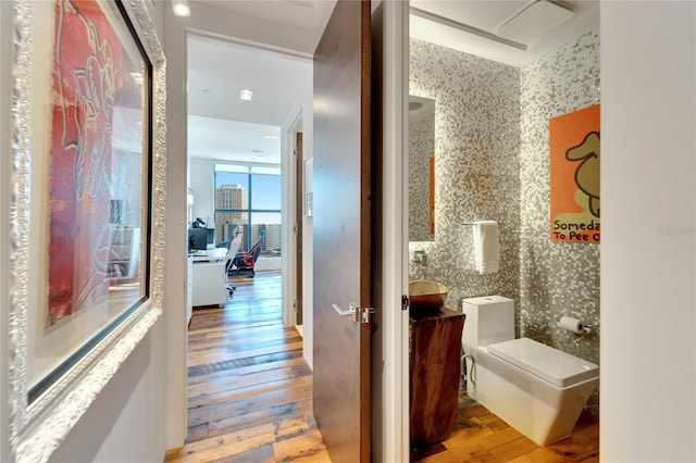 bathroom with hardwood / wood-style floors, vanity, and toilet