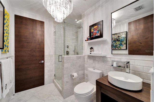 bathroom with vanity, a shower with door, toilet, tile walls, and a notable chandelier