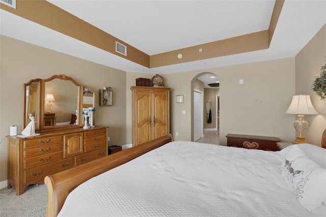 carpeted bedroom with a raised ceiling