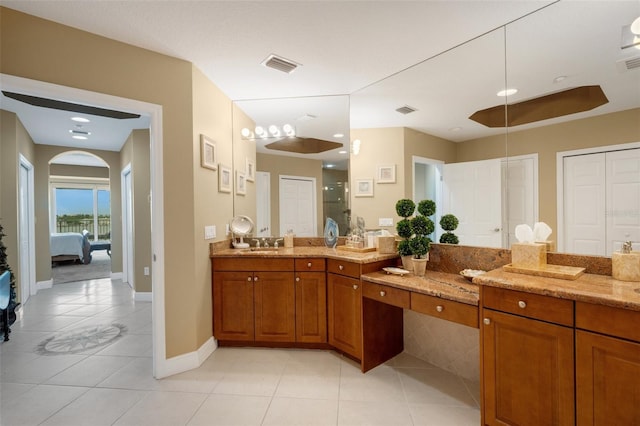 bathroom featuring vanity, a shower, and tile patterned floors