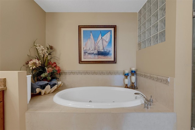 bathroom featuring vanity and a relaxing tiled tub