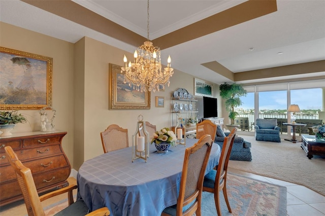 carpeted dining space with ornamental molding, a notable chandelier, and a tray ceiling