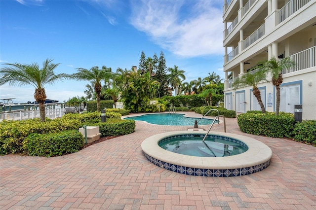 community pool with a hot tub