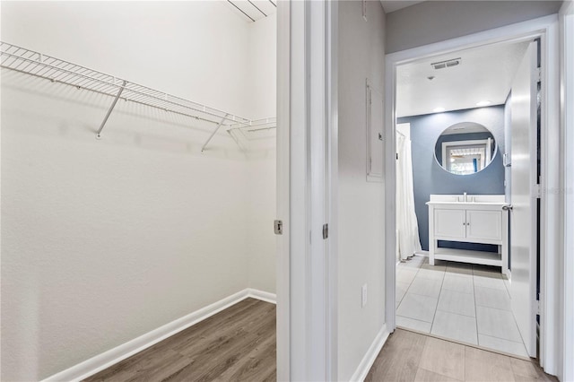 hallway featuring sink and light hardwood / wood-style flooring