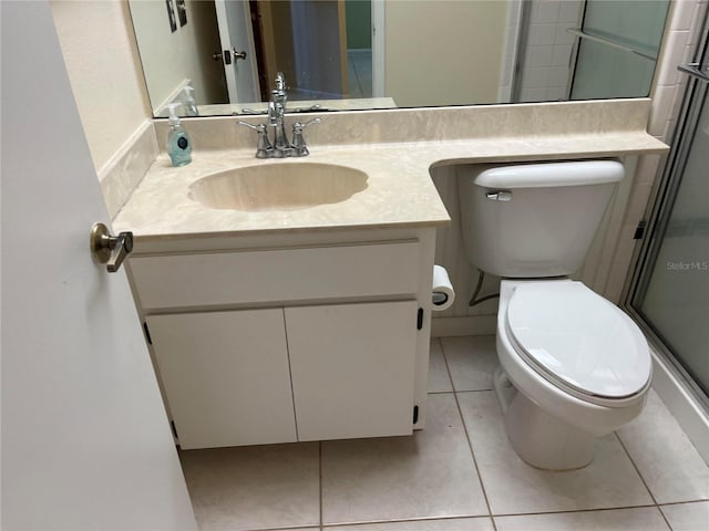 bathroom featuring vanity, a shower with shower door, toilet, and tile patterned floors