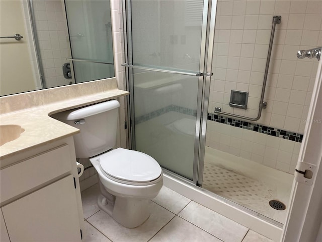 bathroom featuring vanity, toilet, tile patterned flooring, and a shower with door