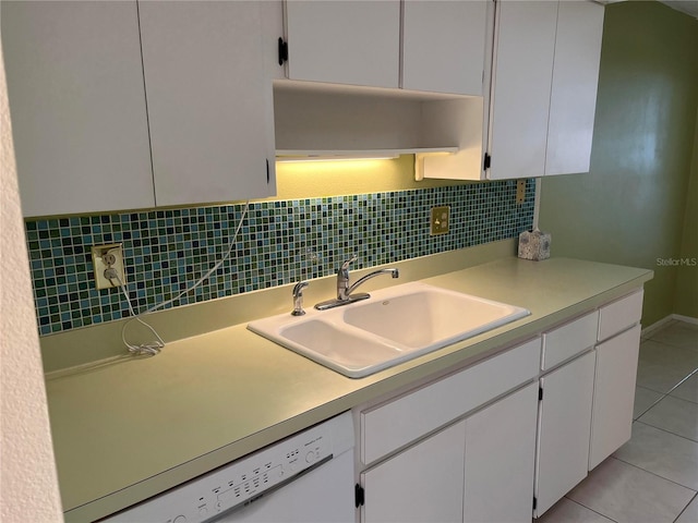 kitchen with light tile patterned flooring, white dishwasher, sink, and white cabinets