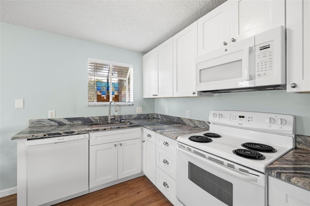 kitchen with dark stone counters, a textured ceiling, white appliances, sink, and white cabinetry