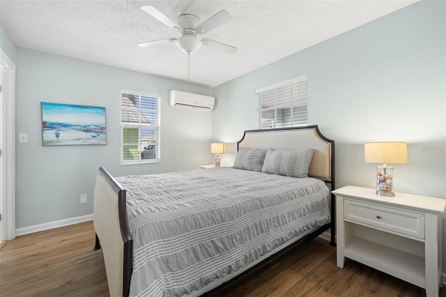 bedroom with a wall mounted air conditioner, a textured ceiling, ceiling fan, and dark wood-type flooring