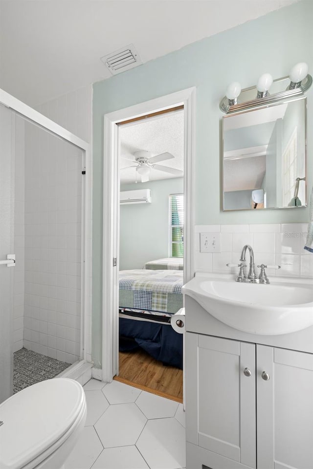 bathroom featuring toilet, tile patterned floors, ceiling fan, and a shower with shower door