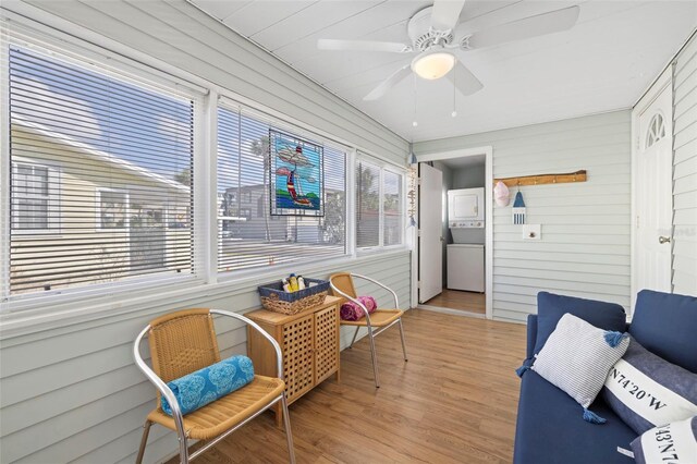 sunroom featuring ceiling fan and stacked washer and clothes dryer