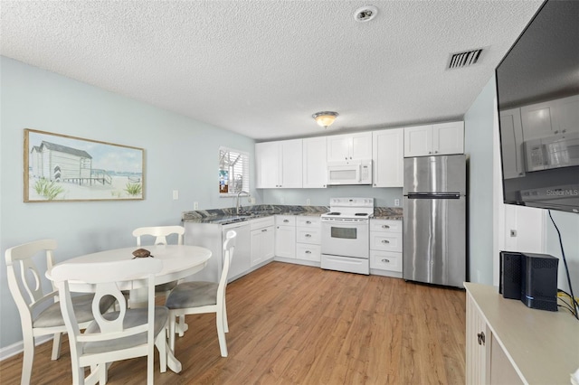 kitchen featuring a textured ceiling, white cabinets, white appliances, and light wood-type flooring