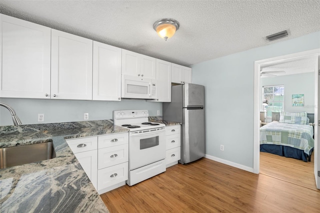 kitchen with white cabinetry, light hardwood / wood-style flooring, white appliances, and sink