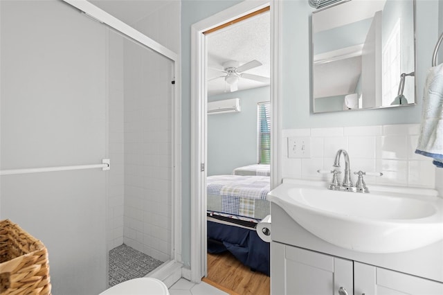 bathroom with ceiling fan, tasteful backsplash, a wall unit AC, wood-type flooring, and tiled shower