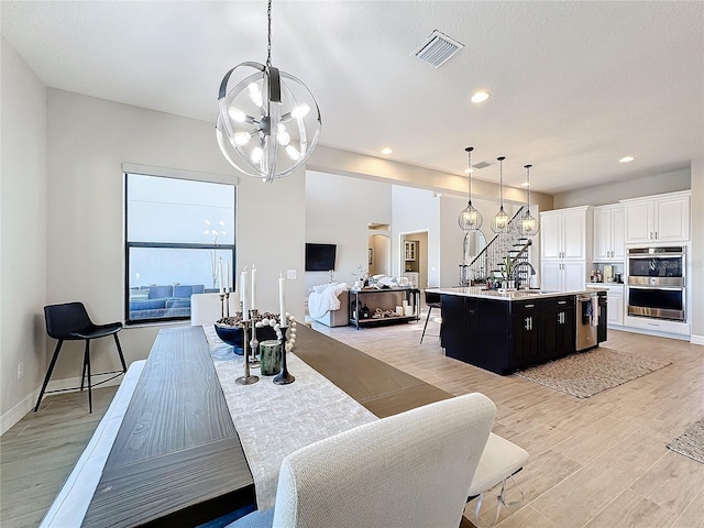 dining room with an inviting chandelier and light wood-type flooring