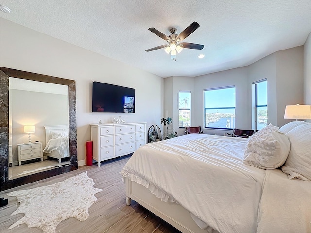 bedroom featuring a textured ceiling, hardwood / wood-style flooring, and ceiling fan